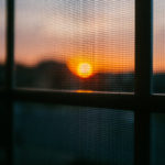 Fliegengitter am Fenster beim Sonnenuntergang